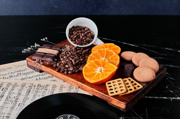 Granos de café marrón con rodajas de naranja y galletas