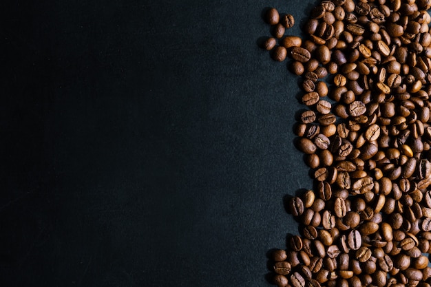 Granos de café sobre fondo oscuro. Vista superior. Concepto de café.