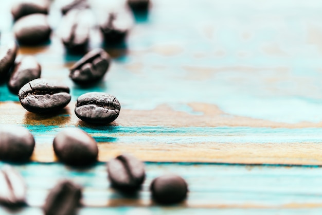 Granos de café sobre una mesa de madera de cerca