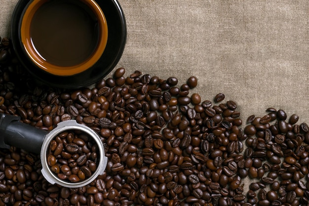 Granos de café y taza de café sobre un fondo de arpillera