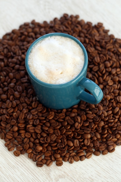 Granos de café con taza en el medio