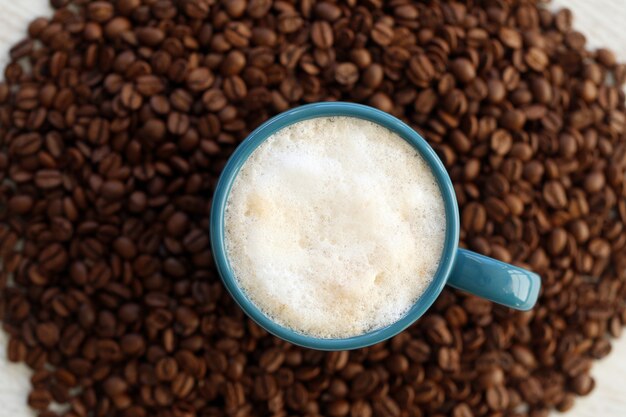 Granos de café con taza en el medio