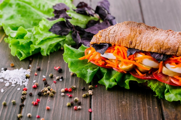 Granos de pimienta, la sal y el verdor se encuentran antes sándwich sano integral