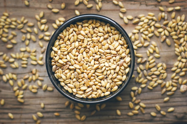 Foto gratuita granos de trigo en un tazón y palomitas de maíz en un tazón, semilla de trigo rústica