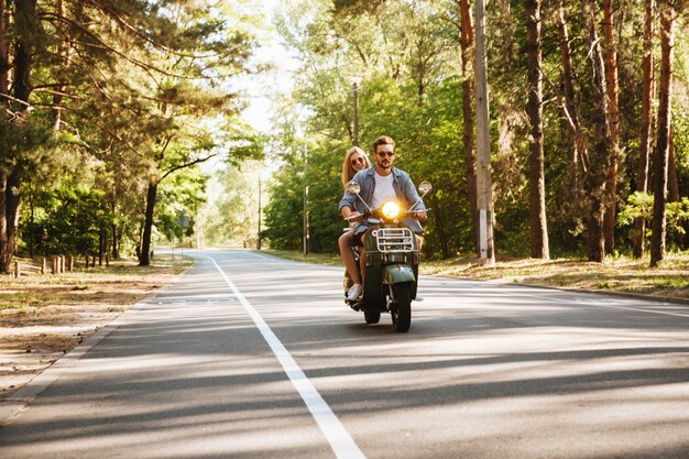 Grave joven barbudo en moto al aire libre.