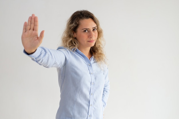 Grave mujer descontenta haciendo gesto de parada