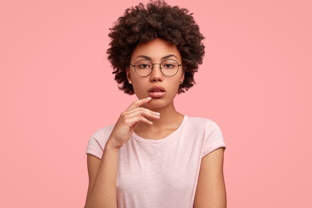 Grave mujer de piel oscura con corte de pelo afro