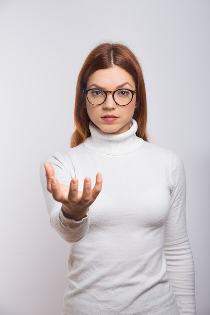 Grave mujer sosteniendo algo en la mano