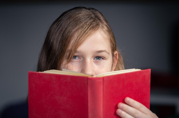 Grave niña leyendo un libro fondo borroso