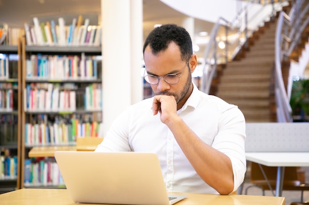 Grave profesional masculino trabajando en computadora