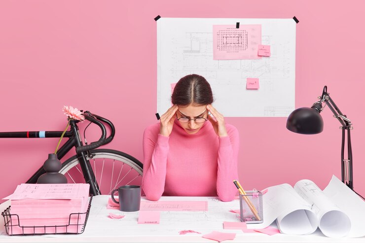 Foto gratuito grave y talentosa joven arquitecta europea que está ocupada en su lugar de trabajo hace que el proyecto de un nuevo complejo residencial concentrado en papeles viste un cuello alto informal intenta reunir con pensamientos