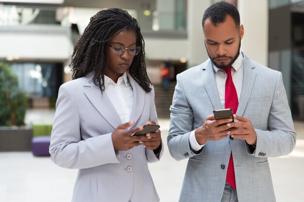 Graves colegas de negocios multiétnicos que consultan internet