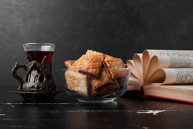 Grietas crujientes en una taza de vidrio con un vaso de té.