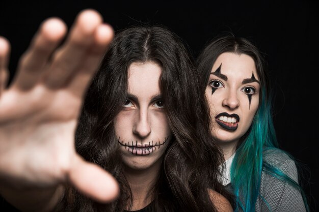 Grim mujeres jóvenes con maquillaje de Halloween