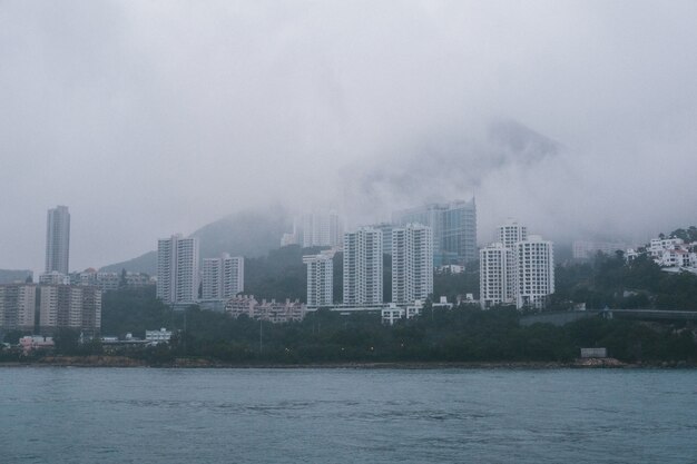 Gris alto rascacielos de hormigón en la costa en tiempo brumoso