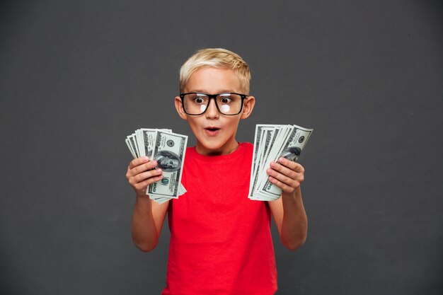 Gritando sorprendido niño niño mostrando dinero.