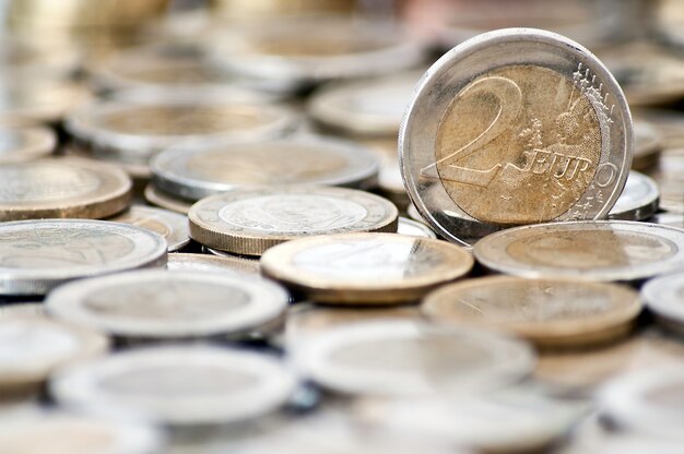 Grungy moneda de 2 euros con monedas en el fondo