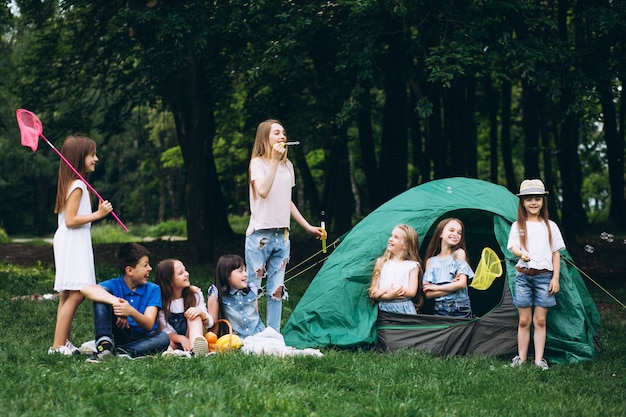 Grupo de adolescentes acampando en el bosque