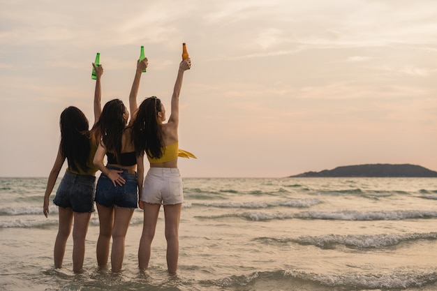 Grupo de adolescentes asiáticas con fiesta celebrando en la playa