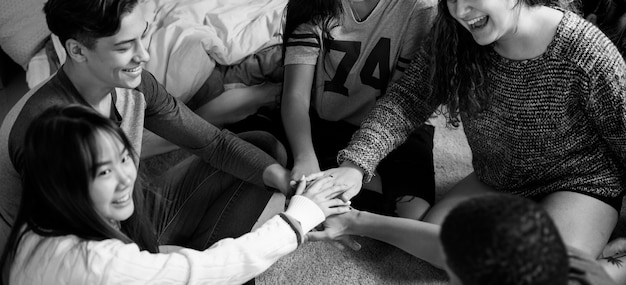 Foto gratuita grupo de adolescentes en un dormitorio poniendo sus manos juntos concepto comunidad y temwork