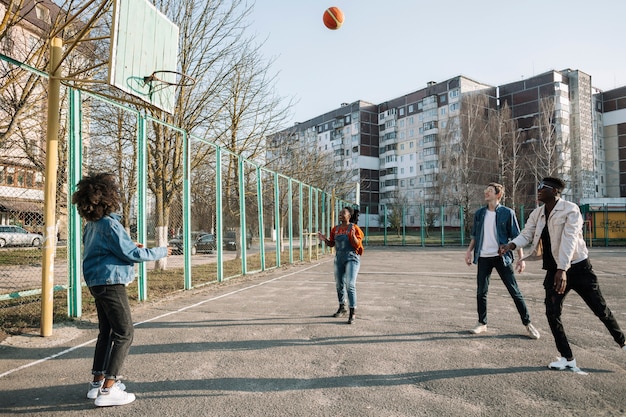 Grupo de adolescentes jugando baloncesto juntos