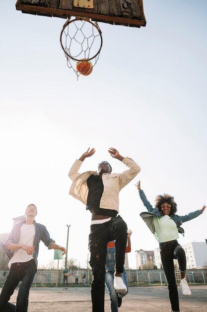 Grupo de adolescentes jugando baloncesto juntos