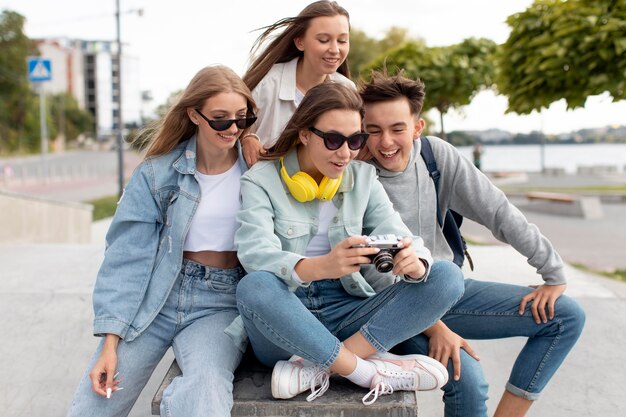 Grupo de adolescentes mirando fotos con una cámara