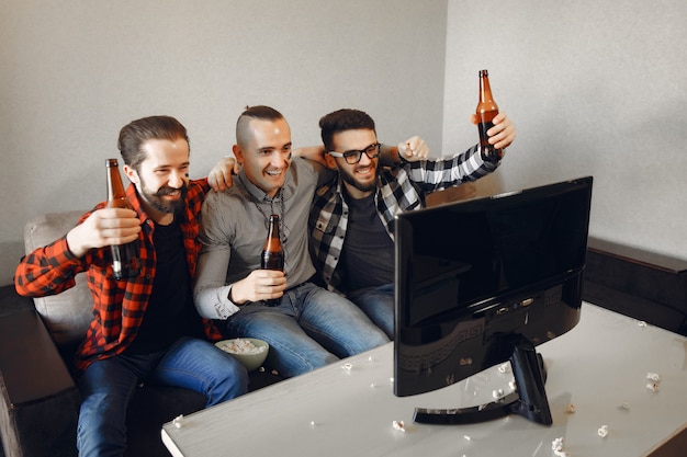 Grupo de aficionados está viendo fútbol en la televisión