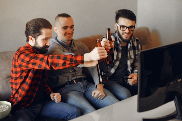 Grupo de aficionados está viendo fútbol en la televisión