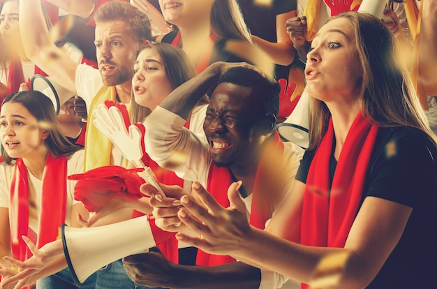 Grupo de aficionados felices están animando a la victoria de su equipo.