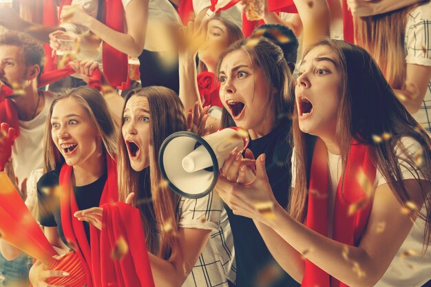 Grupo de aficionados felices están animando a la victoria de su equipo.