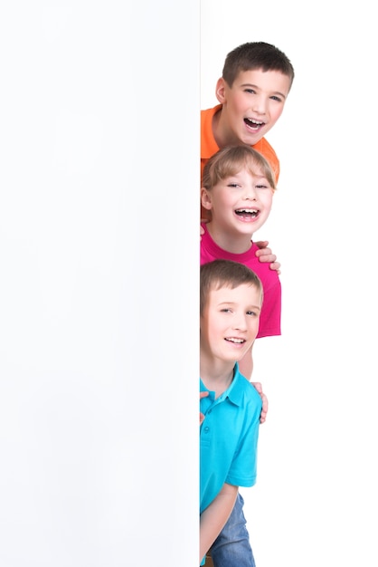 Foto gratuita grupo alegre de niños detrás de la bandera blanca - aislado sobre fondo blanco.