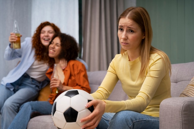 Grupo de amigas en casa viendo deportes juntas