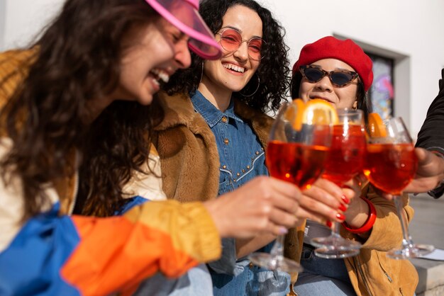 Grupo de amigas disfrutando de una copa de aperol spritz al aire libre