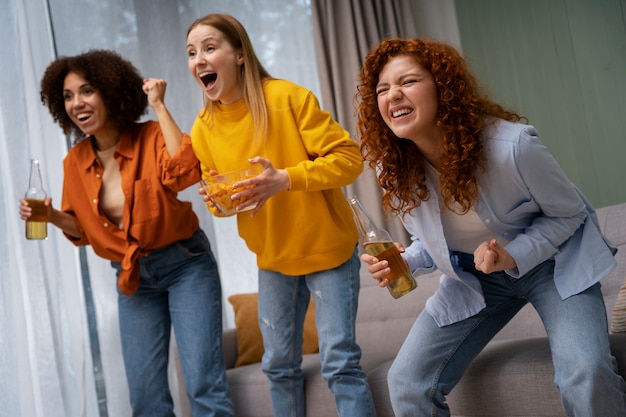 Grupo de amigas viendo deportes en casa juntas