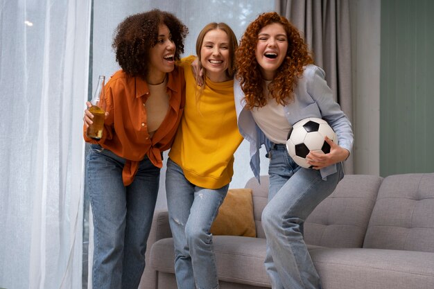 Grupo de amigas viendo deportes en casa juntas