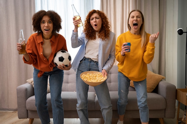 Grupo de amigas viendo deportes en casa juntas