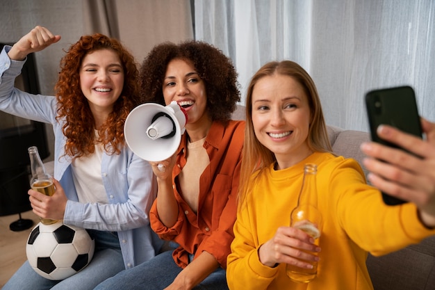 Grupo de amigas viendo deportes en casa juntas