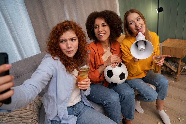 Grupo de amigas viendo deportes en casa juntas