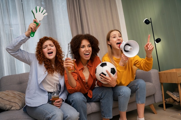 Grupo de amigas viendo deportes en casa juntas