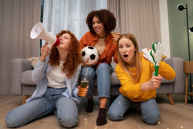 Grupo de amigas viendo deportes en casa juntas