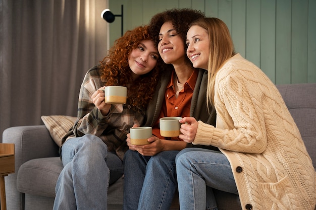 Grupo de amigas viendo deportes en casa y tomando una copa