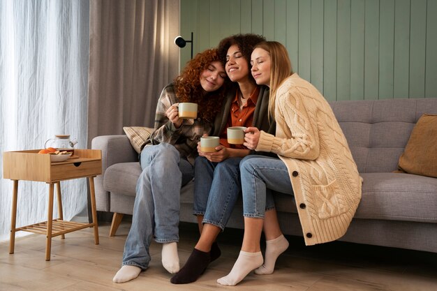 Grupo de amigas viendo deportes en casa y tomando una copa