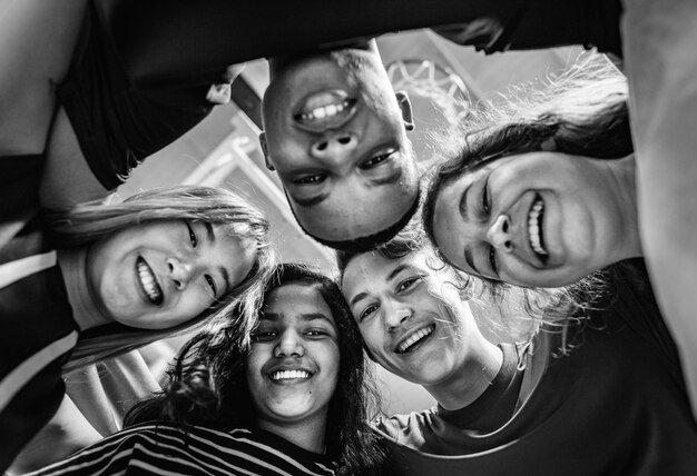 Grupo de amigos del adolescente en un concepto de trabajo en equipo y unidad de la cancha de baloncesto