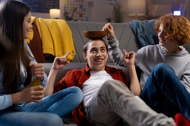 Grupo de amigos adolescentes tomando bocadillos en casa juntos