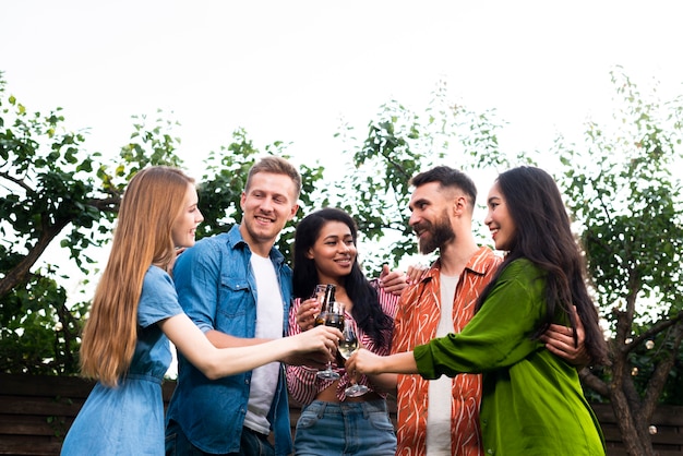 Grupo de amigos de bajo ángulo junto con bebidas