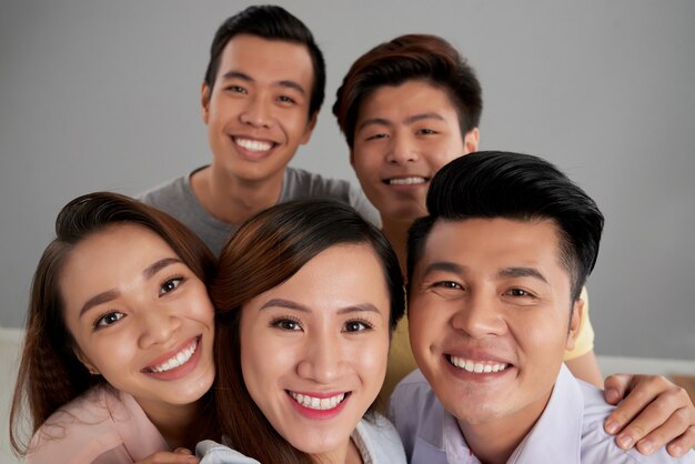 Grupo de amigos asiáticos masculinos y femeninos posando juntos