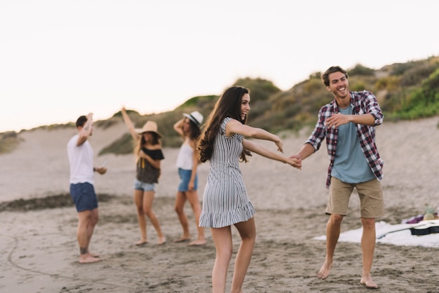 Grupo de amigos bailando en la playa