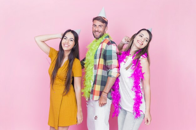 Grupo de amigos bailando sobre fondo rosa