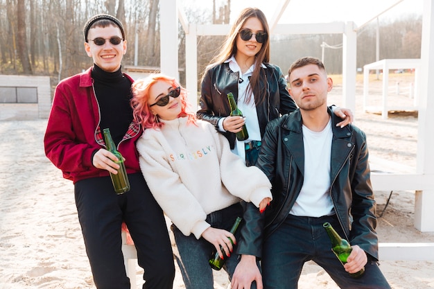 Grupo de amigos bebiendo cerveza y divirtiéndose juntos